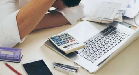 Man counting using calculator and stress in problem with expenses.