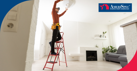 stands on a red ladder, inspecting a ceiling light fixture in a modern living room