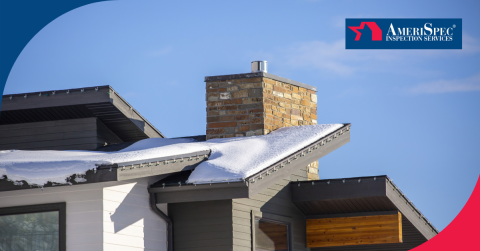 Snow-covered modern roof with a brick chimney under a clear blue sky.