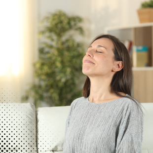 a woman sitting indoors with her eyes closed